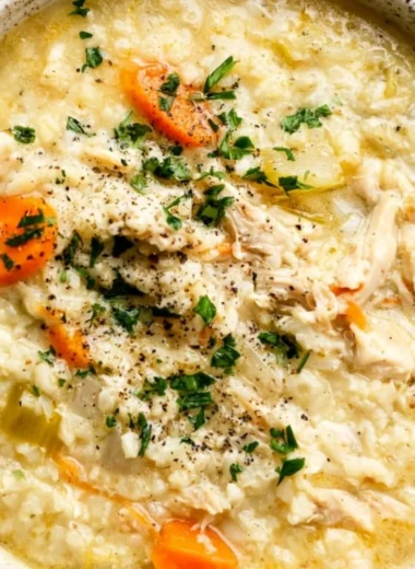 Bowl of Chicken Rice Soup with vegetables and herbs for a comforting meal.