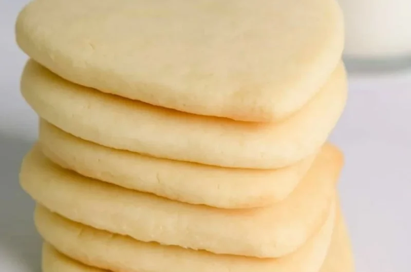 A tray of cozy cut out sugar cookies decorated with icing and sprinkles