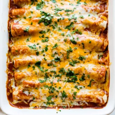 Plate of easy chicken enchiladas topped with cheese and cilantro