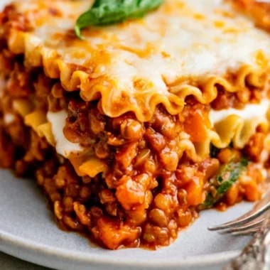 Easy vegan lentil lasagna topped with fresh basil and rich tomato sauce