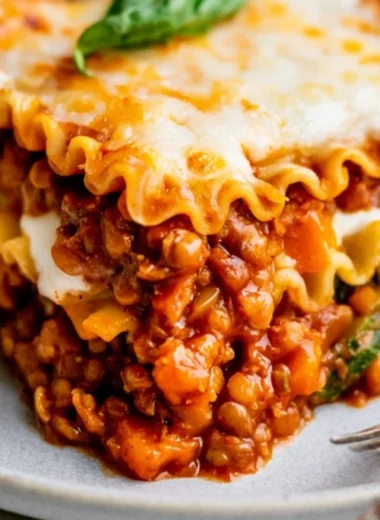 Easy vegan lentil lasagna topped with fresh basil and rich tomato sauce