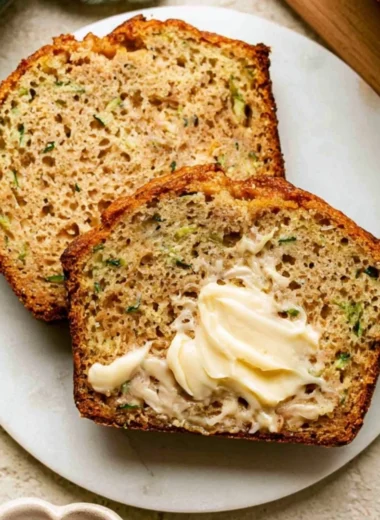 Slice of Greek yogurt zucchini bread on a wooden cutting board