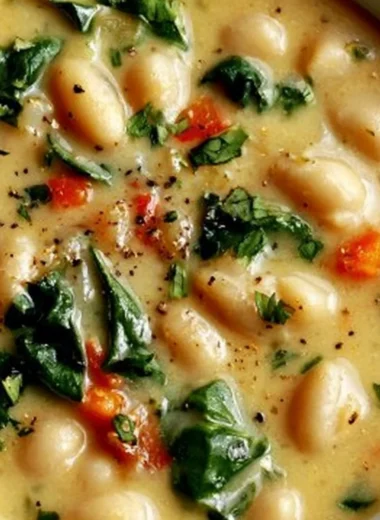 Delicious bowl of high protein white bean soup topped with fresh herbs